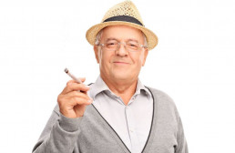 Happy smiling old man enjoying marijuana cigarette