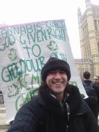 British cannabis marijuana protestor, standing with sign outside British Parliament. 